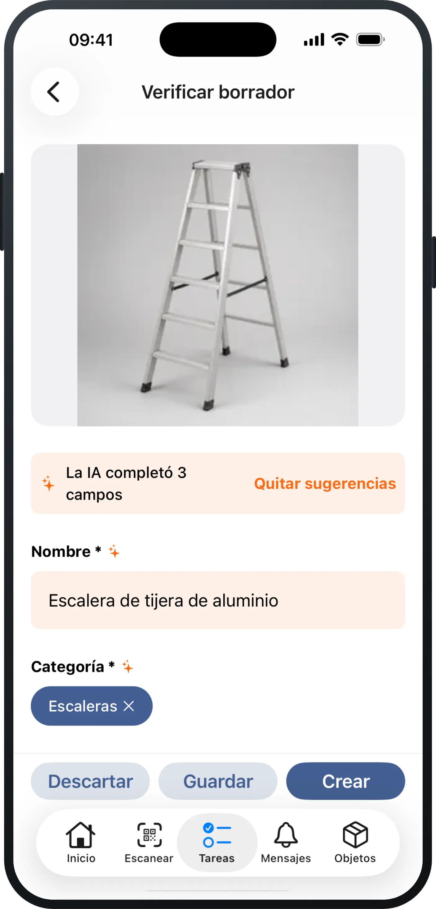 Un iPhone con una captura recién fotografiada en Mango Inventory: arriba la foto de una escalera de tijera de aluminio; debajo, la nota «La IA completó 3 campos» y los campos ya completados «Nombre» («Escalera de tijera de aluminio») y «Categoría» («Escaleras»), y abajo los botones «Descartar», «Guardar» y «Crear».