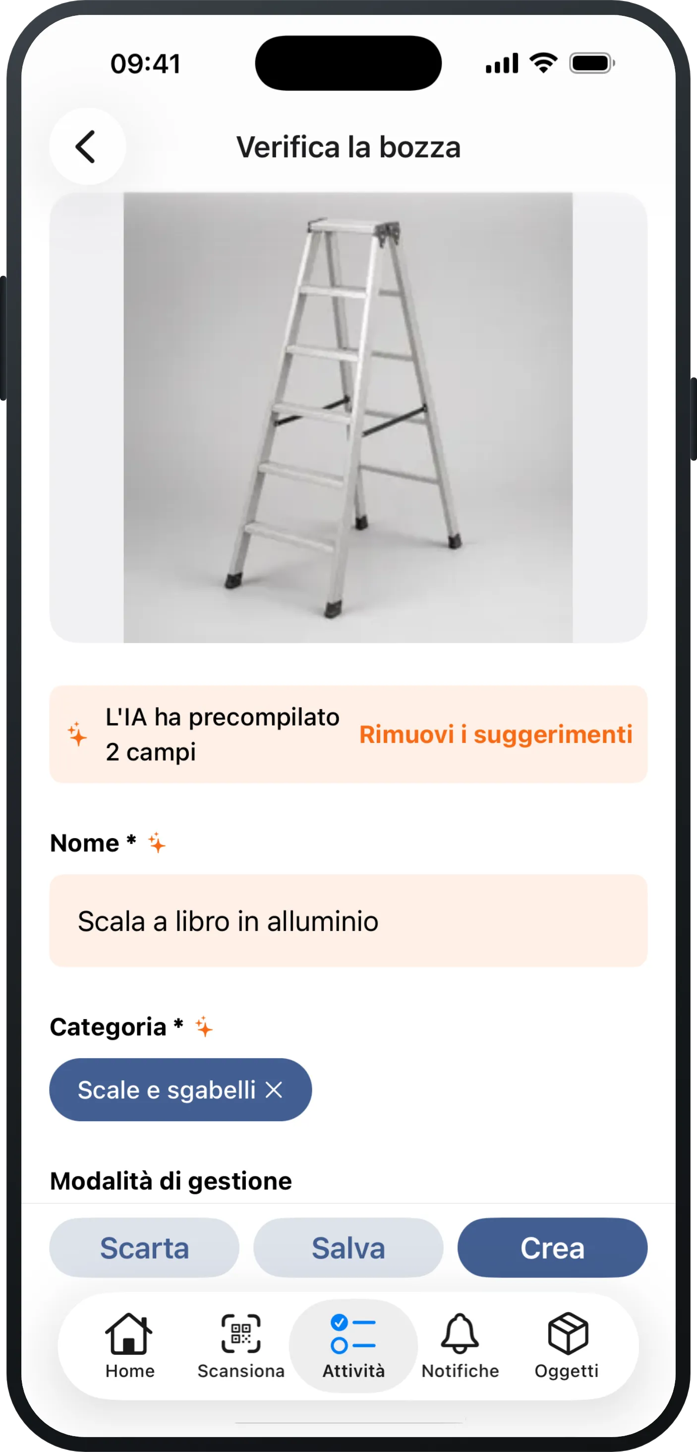 Un iPhone con un'acquisizione appena fotografata in Mango Inventory: in alto la foto di una scala a libro in alluminio, sotto la nota «L'IA ha precompilato 2 campi» e i campi già compilati «Nome» («Scala a libro in alluminio») e «Categoria» («Scale e sgabelli»), in basso i pulsanti «Scarta», «Salva» e «Crea».